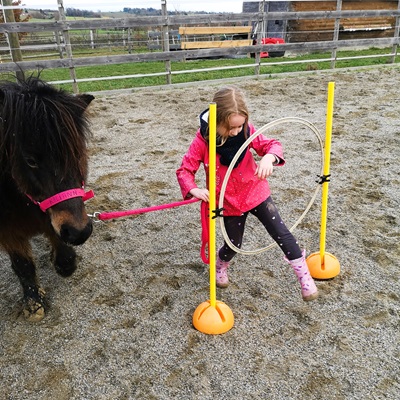 Fille et poney en exercice avec un cerceau