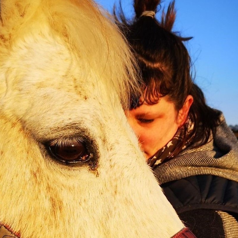 Femme chargée d'émotions câlinant un Poney