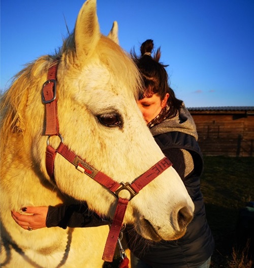 Femme embrassant un Poney